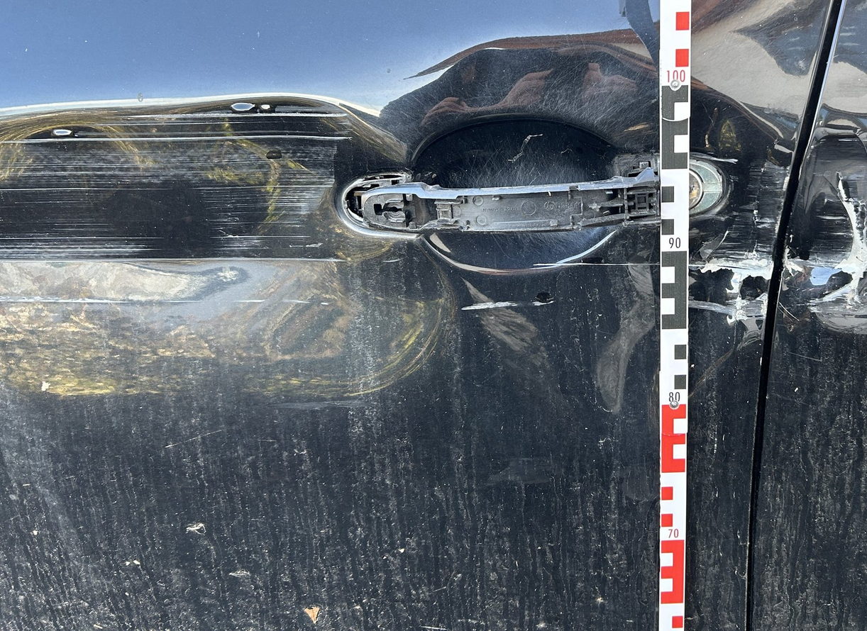Beschädigter Türbereich, daneben ein Messstab für die Höhenangabe